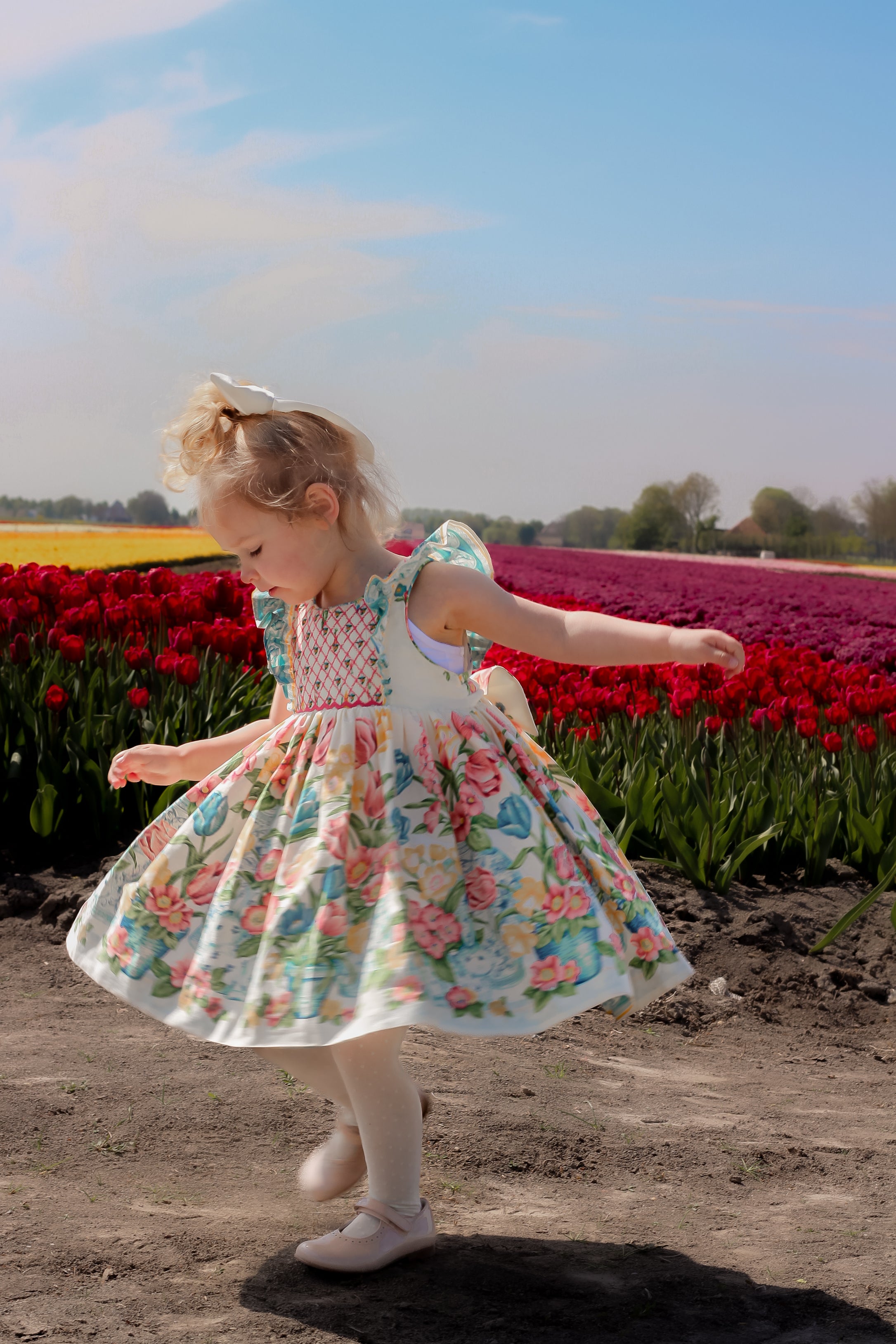 Image Title Charlotte sy Dimby classic timeless traditional smocked dresses for babies and girls handmade French style children clothing paris boutique twirling princess dress floral print tulip spring summer photography netherlands